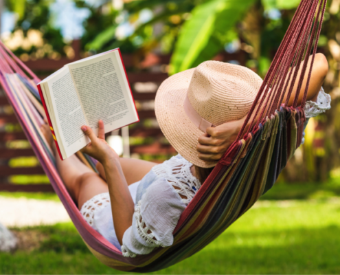 Women sitting in a hammock reading to relax this summer