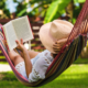 Women sitting in a hammock reading to relax this summer
