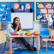 Teacher sat alone in a classroom looking worried. For the Tips for teachers who feel like they are failing at school blog post.